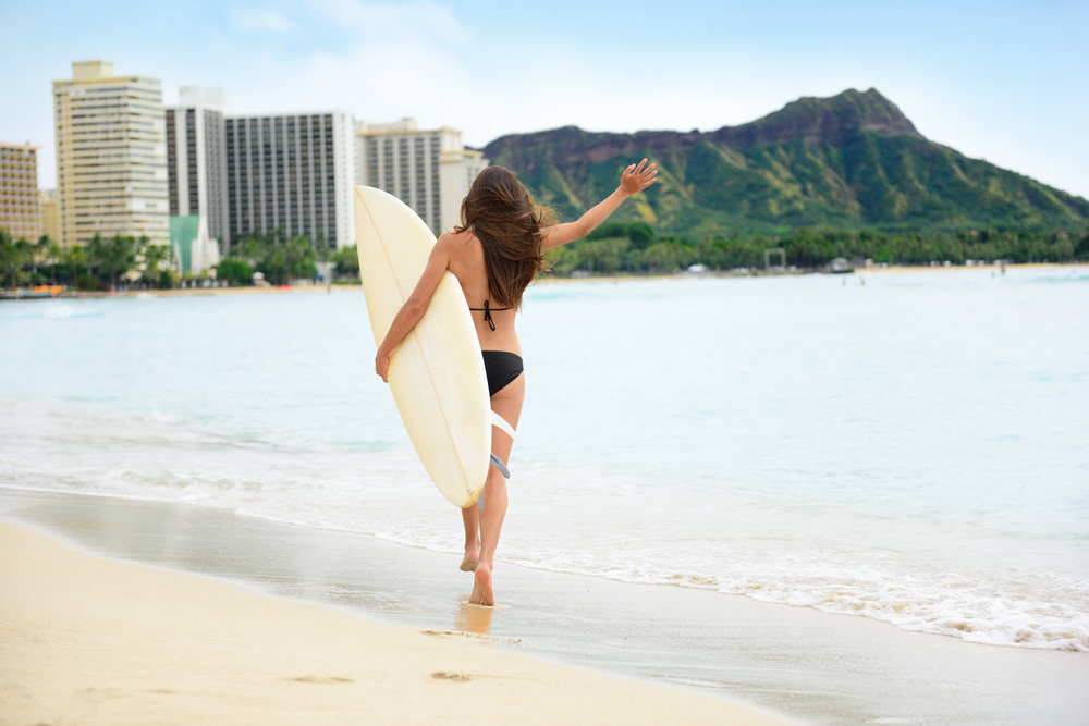 Woman going to surf in Waikiki Beach