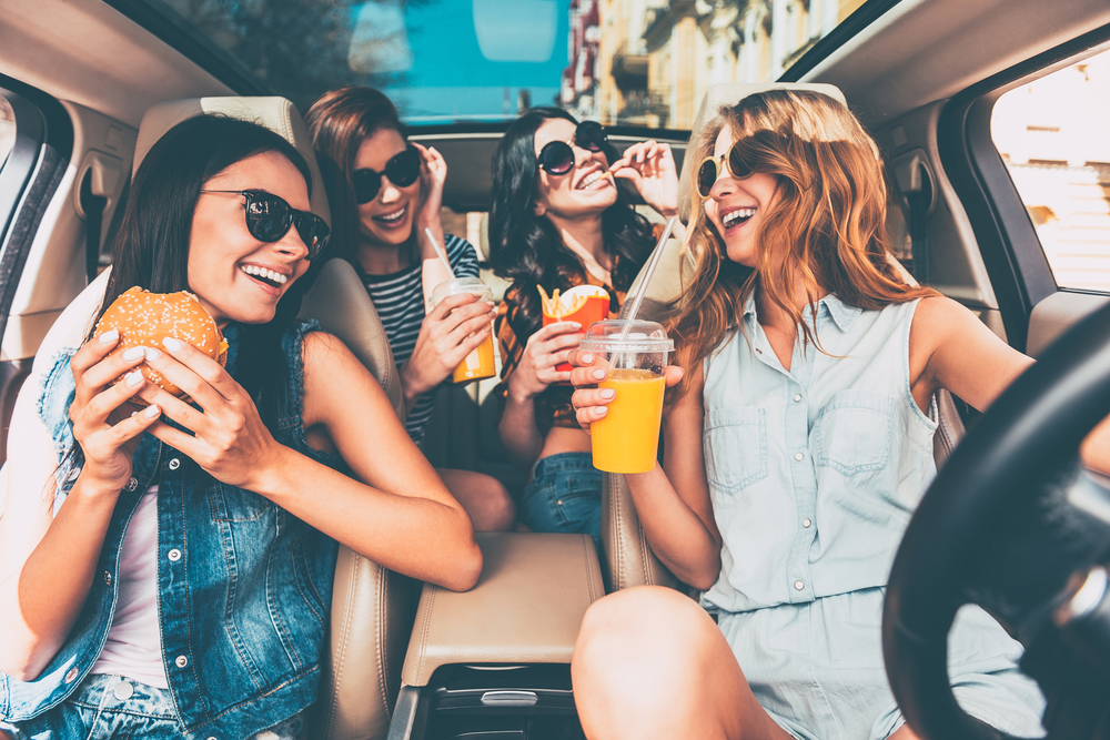 Women eating in a car on a road trip 