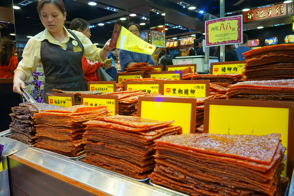 Asian woman selling preserved meat in Macau, China.